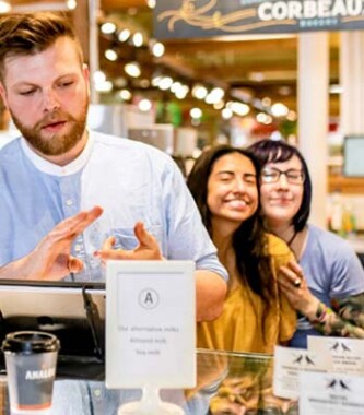 Three Market guests smiling while ordering from Analog Coffee